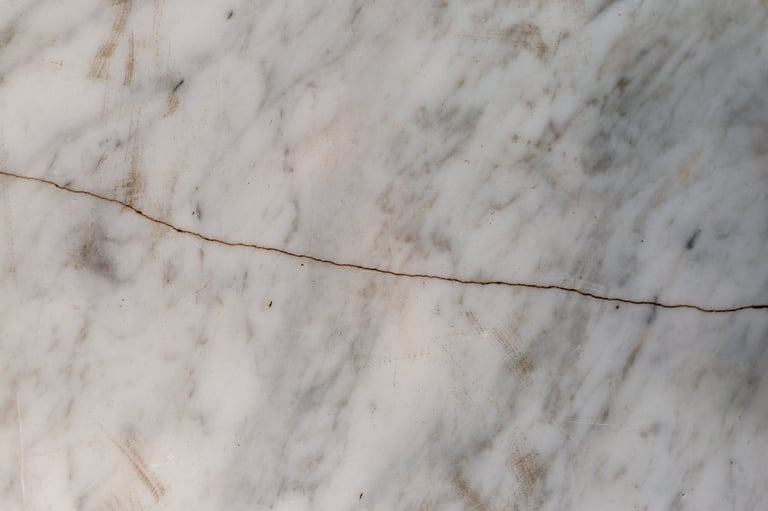 White marble surface featuring a prominent crack and natural stone texture